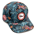 Baseball cap with blue tropical leaf print and a round patch that says Made in USA with a checkered-flag logo on the front panel