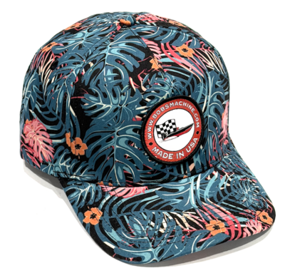 Baseball cap with blue tropical leaf print and a round patch that says Made in USA with a checkered-flag logo on the front panel